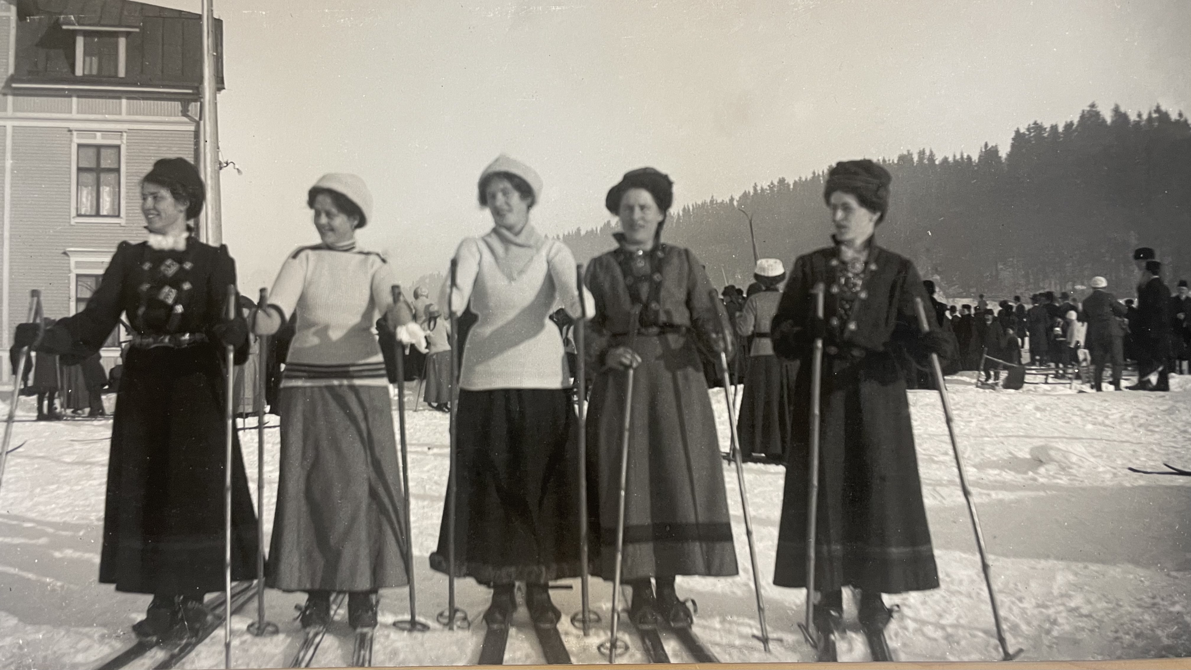 Svartvitt fotografi av fem kvinnor som ska åka skidor